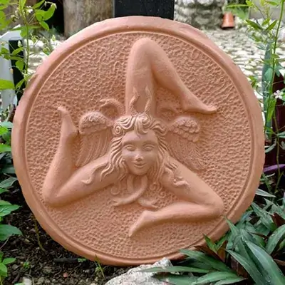 Peça decorativa redonda em terracota com figura feminina em relevo
